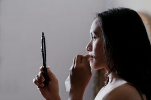 woman looking to mirror and wiping her lips